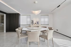 A contemporary living dining room with a white marble table and chairs.