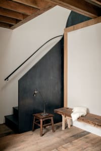 Minimalist designed staircase entry with concrete and wooden elements.