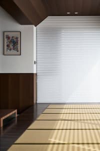 A minimalist interior design featuring a bamboo rug on a wooden floor.
