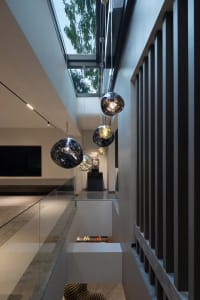 Modern residential staircase with glass railings and pendant lights