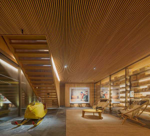 Interior of a modern retail space with wooden finishes and a yellow vintage snowmobile on display.