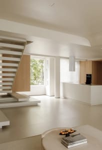 A modern minimalist living space featuring wood and white materials.