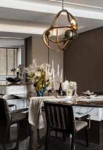 Modern dining room featuring a marble dining table with metal chairs and a contemporary light fixture.