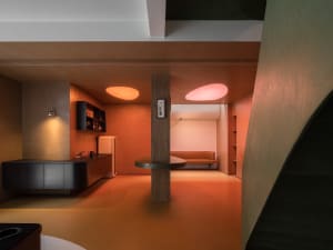 Modern living room with concrete walls, Belgian limestone flooring, and steel accents.