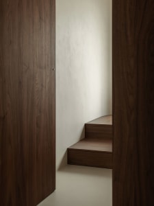 A modern, linear staircase with wooden treads and walls.
