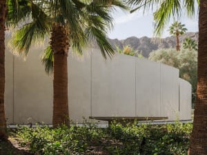 Modern architectural furniture surrounded by lush greenery.