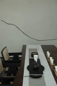 A modern tea room featuring minimalist furniture, wooden table, and white accessories.