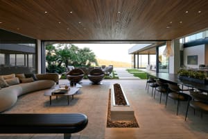 A modern living room with concrete flooring, a minimalist design, and a view of the outdoors.