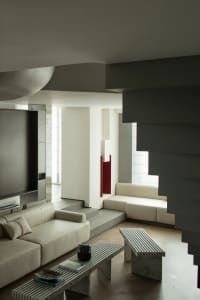 Minimalist living room with concrete furniture and clean lines.