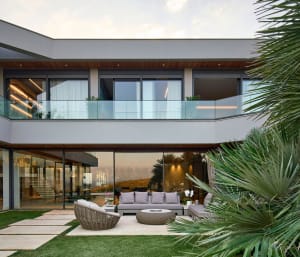 A modern residential patio featuring a concrete floor and comfortable seating arrangements.