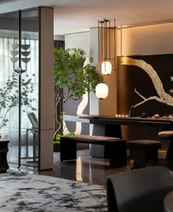 A modern living room featuring wooden furniture, glass windows, and metal accents.
