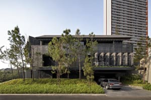 A modern residential home featuring black metal facade and greenery on the rooftop.