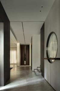 A modern entrance hallway with minimalist design elements, featuring concrete flooring and clean lines.
