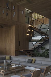Modern living room with wooden furniture, glass coffee table, and black metal chandelier.