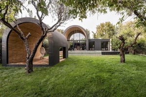 A modern backyard featuring wooden structures and glass windows.