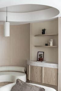 A modern bedroom featuring wood-paneled walls and a concrete shelf, with a hanging lamp and decorative objects on the shelf.