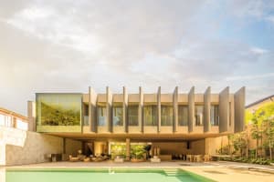 Modern building with sandstone exterior, large windows, and a swimming pool.
