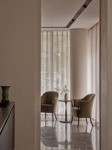 A modern living room featuring marble flooring and upholstered furniture made of fabric.