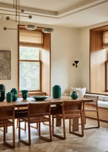 A minimalist interior design with wooden furniture, large windows, and green vases.