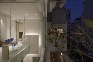 Modern residential interior features glass walls and light-filled spaces.
