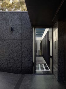 Modern entrance featuring terrazzo floor and black walls and ceiling
