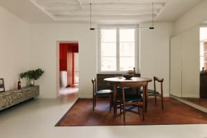 Modern dining room with wooden table and chairs, featuring a red and white color palette