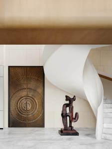 A grand entrance featuring a decorative bronze door with intricate designs and a white curved staircase leading to it.