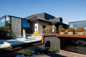 Modern residential exterior featuring concrete, glass, and metal materials