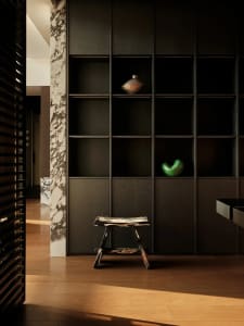 A modern interior design featuring a mix of dark wood furniture, marble accents, and minimalist decor.