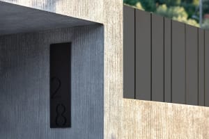 Modern entrance featuring a textured concrete wall and horizontal wooden panels.