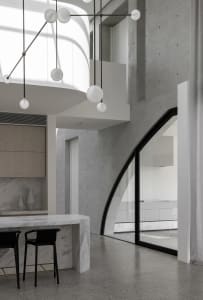 Modern kitchen with concrete walls, marble countertops, and minimalist design.