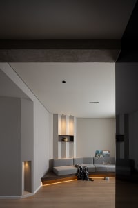 Modern living room with concrete walls, wooden floor, and upholstered furniture.