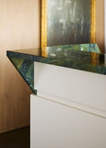 Close-up of a modern interior featuring a marble chair, highlighting the material and design.