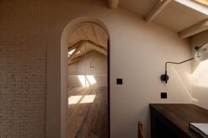 A modern loft office featuring a brick-clad ceiling and wooden flooring.