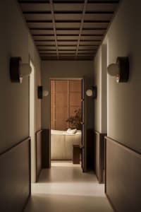 A minimalist hallway with wooden paneling and warm lighting.