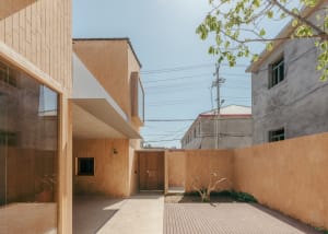 Modern house exterior with wooden facade and concrete roof.