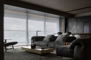 Modern living room with a metal coffee table, leather sofa, and stone accents.