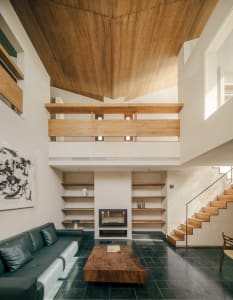 A modern living room with wooden furniture and a black floor.