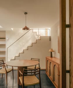 Modern interior with a wine bar, kitchen, and breakfast nook featuring wooden furniture and concrete flooring.