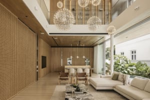 A spacious modern living room with wooden elements, featuring minimalist furniture and large windows.