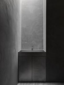 A sleek, modern concrete sink integrated into a minimalist bathroom design.