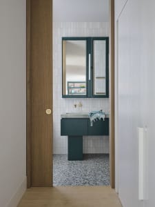 A modern bathroom featuring a minimalist design with gray terrazzo tiles on the floor and walls.