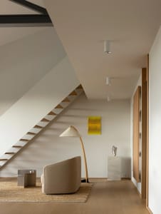 Modern residential interior with a minimalist design featuring wood, concrete, and metal elements.