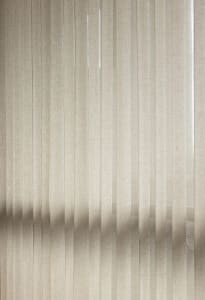 Striped taupe textile curtain hanging in a window.