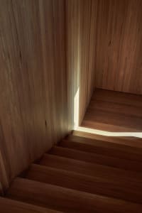 A wooden staircase with sunlight filtering through, creating a warm and inviting atmosphere.