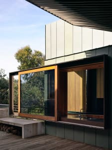 A modern house exterior with concrete walls and bamboo accents.