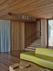 A modern living room featuring a yellow sofa and wooden paneling