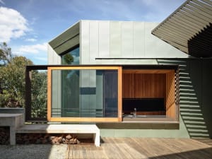 Modern, minimalist exterior of a house with sleek, metal exterior walls and large windows.