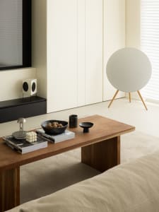 A minimalist living room featuring a wood coffee table and a concrete wall cabinet.