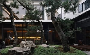An elegant, modern restaurant interior with concrete flooring and a minimalist design.